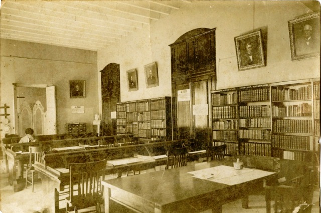 Foto de Sala de lectura de la Biblioteca Nacional en el edificio de la antigua Maestranza de Artillería, se observa la escultura de Bachiller en el salón. Década de 1920. Colección de fotografías BNJM.